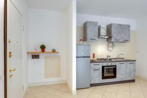 a small kitchen with a refrigerator and a sink at Il Broletto Apartment - Affitti Brevi Italia in Lecco