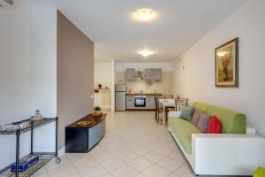 Il comprend un salon avec un canapé vert et une cuisine. dans l'établissement Il Broletto Apartment - Affitti Brevi Italia, à Lecco