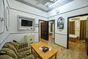 OYO 140 Al Musafir Hotel في بركاء: غرفة معيشة مع أريكة وطاولة