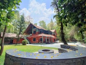 a house with a fire pit in front of a yard at Adrak Mountain Mist Forest Resort in Pulpally