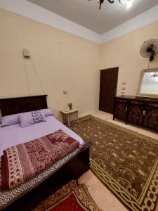 a bedroom with a bed and a rug at Green House in Al Manshīyah