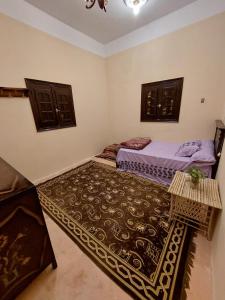 a bedroom with two beds and a rug in it at Green House in Al Manshīyah