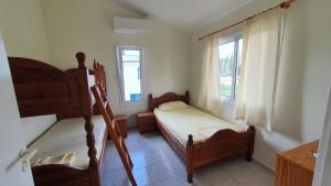 una camera con due letti a castello e due finestre di Villa Victoria 400 meters to the beach a Peyia Altre 13 foto