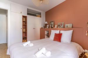 a bedroom with a large white bed with towels on it at Appartement proche centre ville et face a l Erdre in Nantes