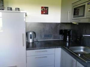 a kitchen with white cabinets and a sink at Ferienhaus Nienaber in Grafenau