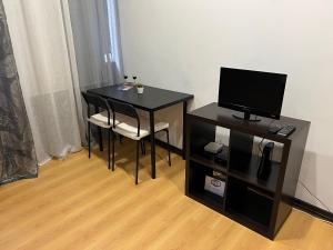 a black table with a chair and a television at Espaço_Zero[Downtown] 01 in Porto