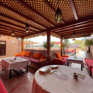 ein Wohnzimmer mit Sofas und Tischen auf einer Terrasse in der Unterkunft Riad Rêves D'orient in Marrakesch