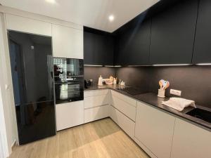 een keuken met witte kasten en zwarte apparaten bij Precioso apartamento a pie de playa in Estepona