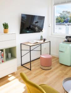 a living room with a desk and a tv at Louis & Louise Apartments & Rooms I Digital Check In in Bremen