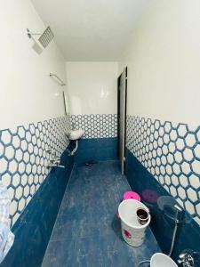 a blue and white bathroom with a toilet and a sink at RJ Villa farmhouse in Daman