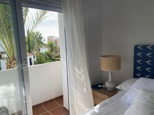 een slaapkamer met een bed en een raam met uitzicht bij Precioso apartamento a pie de playa in Estepona +20 foto's