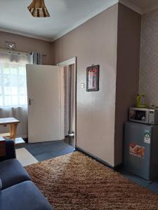 ein Wohnzimmer mit einem Sofa und einem Kühlschrank in der Unterkunft Kwinet Luxury Villa in Eldoret