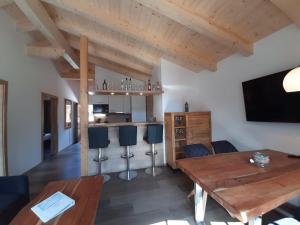 een woonkamer met een houten tafel en een bar bij Hochalmbahnen Chalets Rauris 1-08 WE2, Maislaufeldweg 1e OG in Rauris