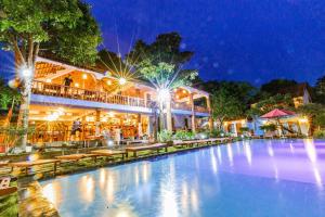 a resort with a large swimming pool at night at Star Hill Village Resort Phu Quoc in Phú Quốc