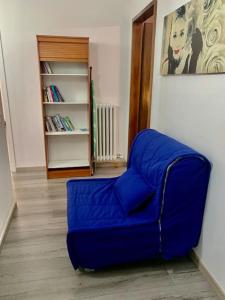 - un canapé bleu dans un salon avec une étagère dans l'établissement Appartamento Santa Teresa, fiera/centro Verona, à Vérone