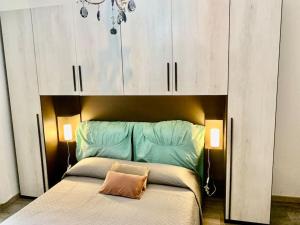 - une chambre avec un lit doté d'une tête de lit et de placards blancs dans l'établissement Appartamento Santa Teresa, fiera/centro Verona, à Vérone