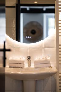 two towels on a bathroom sink in front of a mirror at Hôtel Le Français in La Flotte