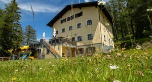 a large building in a field of grass with flowers at Skihütte Zams in Zams