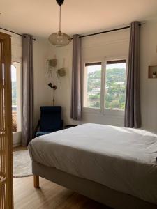 - une chambre avec un grand lit et 2 fenêtres dans l'établissement Cozy place, big roof terrace & spectacular views., à Cabrils