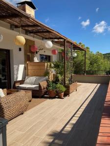 une terrasse en bois avec pergola sur une maison dans l'établissement Cozy place, big roof terrace & spectacular views., à Cabrils