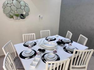 a white dining room table with white chairs and a white table and chairsktop at Sasna in Doha