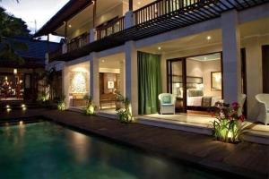a house with a swimming pool in front of it at Cinta inn in Ubud