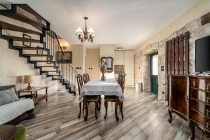 een eetkamer met een tafel en stoelen en een trap bij Villa Little Arya in Otok