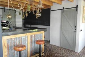 een keuken met een schuurdeur en 2 krukken bij Landgoed Versteegh nabij heerlijkheid Mariënwaerdt in Beesd