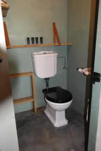 een badkamer met een wit toilet en een zwarte stoel bij Landgoed Versteegh nabij heerlijkheid Mariënwaerdt in Beesd