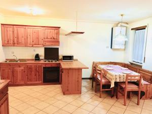 una cocina con armarios de madera y una mesa con comedor. en Casa Bianchi, en Asiago