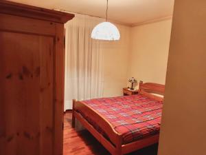 1 dormitorio con cama y lámpara de araña en Casa Bianchi, en Asiago