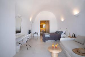 a white living room with a bed and a couch at On the Cliff in Fira