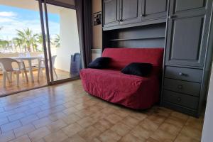 ein rotes Sofa im Wohnzimmer mit einem Tisch in der Unterkunft Studio 4 People - Christmas Market - Port - Beach in Le Barcarès