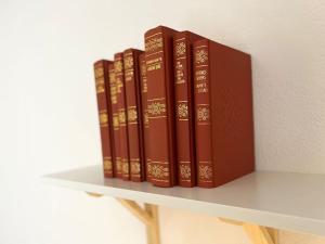 a row of books sitting on a shelf at Ottanio Lake Apartment in Pisogne