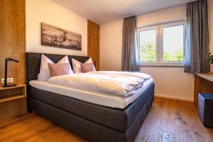 a bedroom with a large bed in front of a window at Dahoam bei Weber’s in Ascha