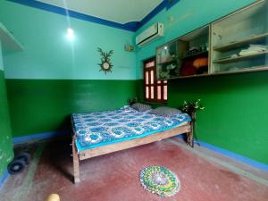 a bedroom with a bed in a green room at Ansari House in Bodh Gaya