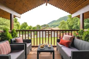 a patio with chairs and a table on a deck at Espectacular apartamento de madera frente al río Ter - Camprodon in Camprodon
