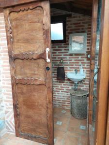 una puerta de madera en un baño con lavabo en Casa Rural El Ñeru, en Llanes