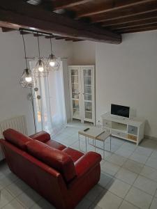 a living room with a red couch and a tv at Le Patio in Villegailhenc