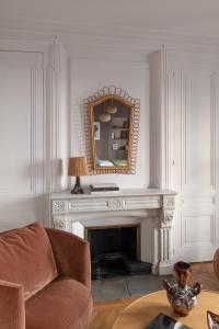 a living room with a mirror over a fireplace at MiHotel Plat in Lyon