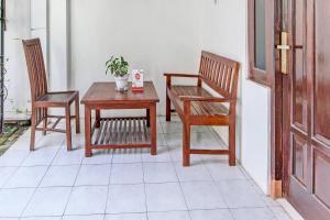 patio z 2 krzesłami, stołem i krzesłami w obiekcie OYO 91803 Gita Graha Guest House Syariah w mieście Yogyakarta
