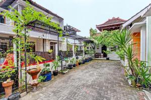 une cour avec des plantes en pot sur le côté d'un bâtiment dans l'établissement OYO 91803 Gita Graha Guest House Syariah, à Yogyakarta