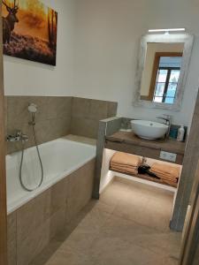 une salle de bain avec une baignoire et un lavabo et une baignoire dans l'établissement Hochalmbahnen Chalets Rauris 1-15 WE1, Maislaufeldweg 1o EG, à Rauris