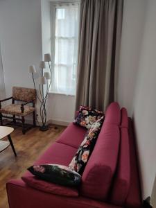 un sofá púrpura en una sala de estar con ventana en Appartement 5 personnes proche du Mont Saint Michel, en Val Couesnon