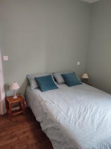 1 dormitorio con 1 cama grande con almohadas azules en Appartement 5 personnes proche du Mont Saint Michel, en Val Couesnon