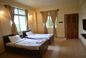 um quarto de hotel com duas camas e uma janela em TreeTops Residency em Shillong