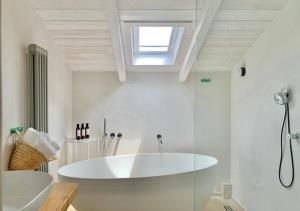 a white bathroom with a tub and a sink at Santa Lucia Maccarese - Residenza Agricola in Maccarese