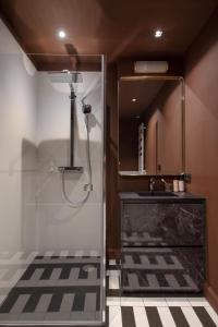 a bathroom with a shower with a sink and a mirror at MiHotel Plat in Lyon