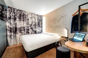 B&B HOTEL Paris Ivry Quai de Seine في إيفري سور سين: غرفة مع سرير ومكتب مع لاب توب