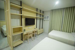 um quarto de hotel com uma cama e uma secretária e um quarto em Twin Hearts Residences 1 em Roxas City